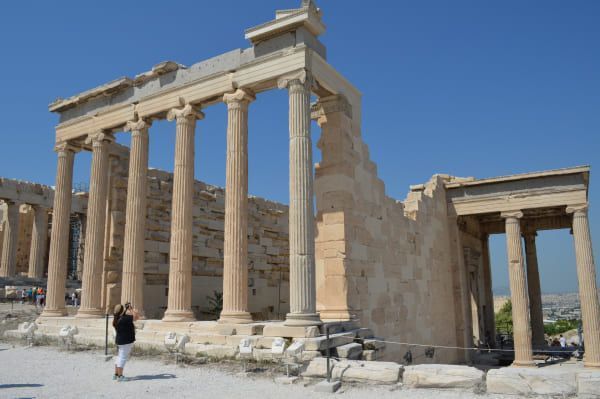 Person taking pictures of Old Temple of Athena