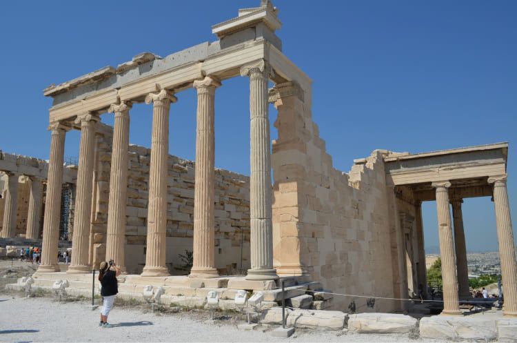 Girl taking pictures of the Old temple of Athena